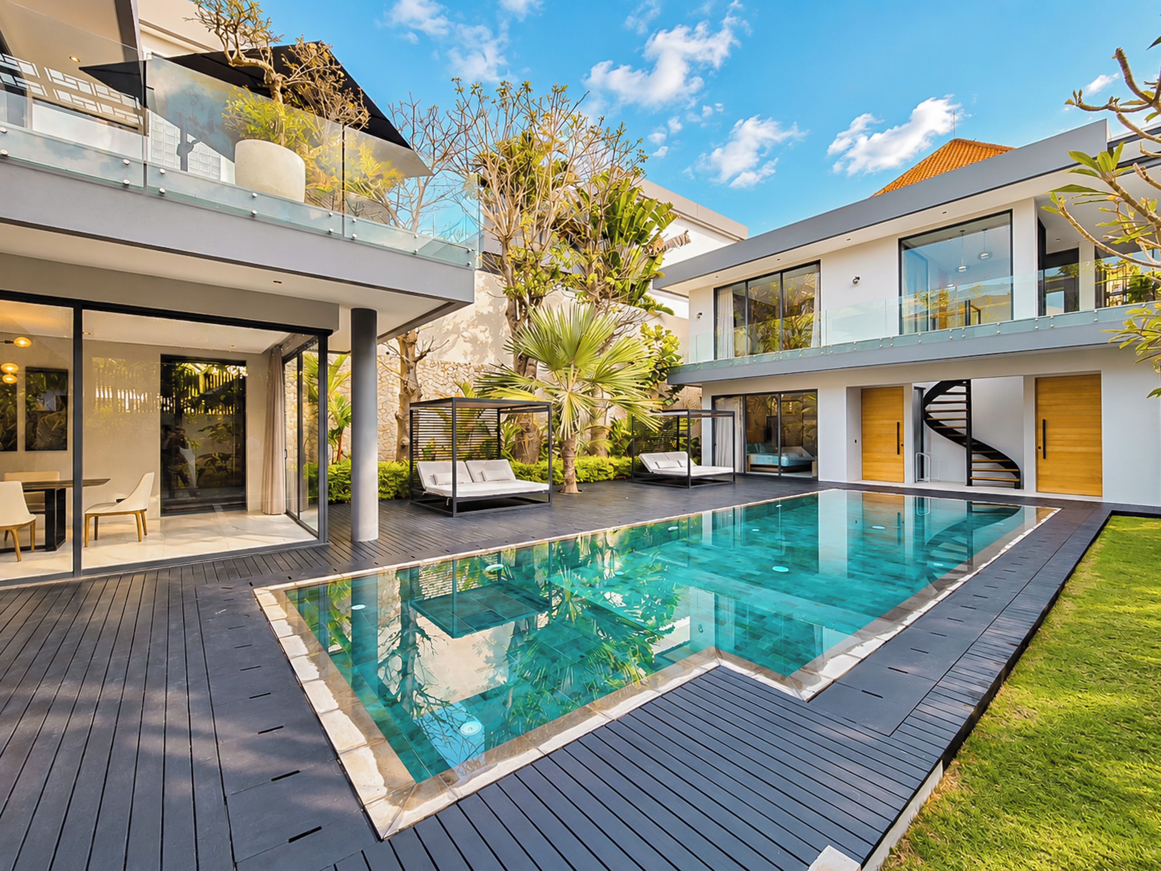 Una casa moderna con piscina, zona de estar exterior y una escalera.