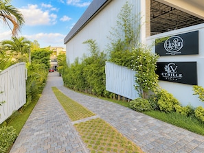 Un chemin menant à un bâtiment sur lequel on peut lire les panneaux « Elysian Heights » et « Cyrille Villa ».