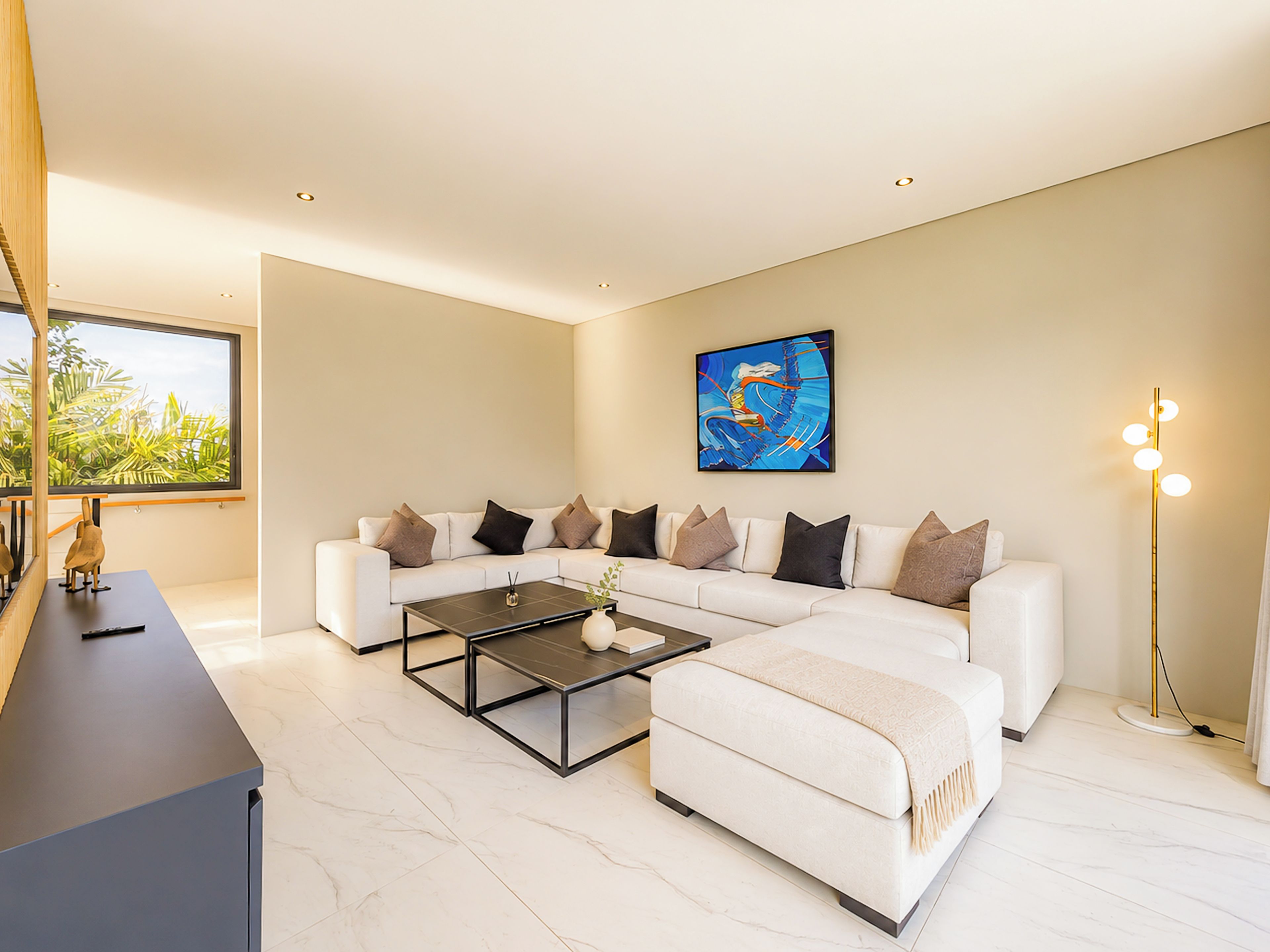 A modern living room with a sectional sofa, a coffee table, and a floor lamp.