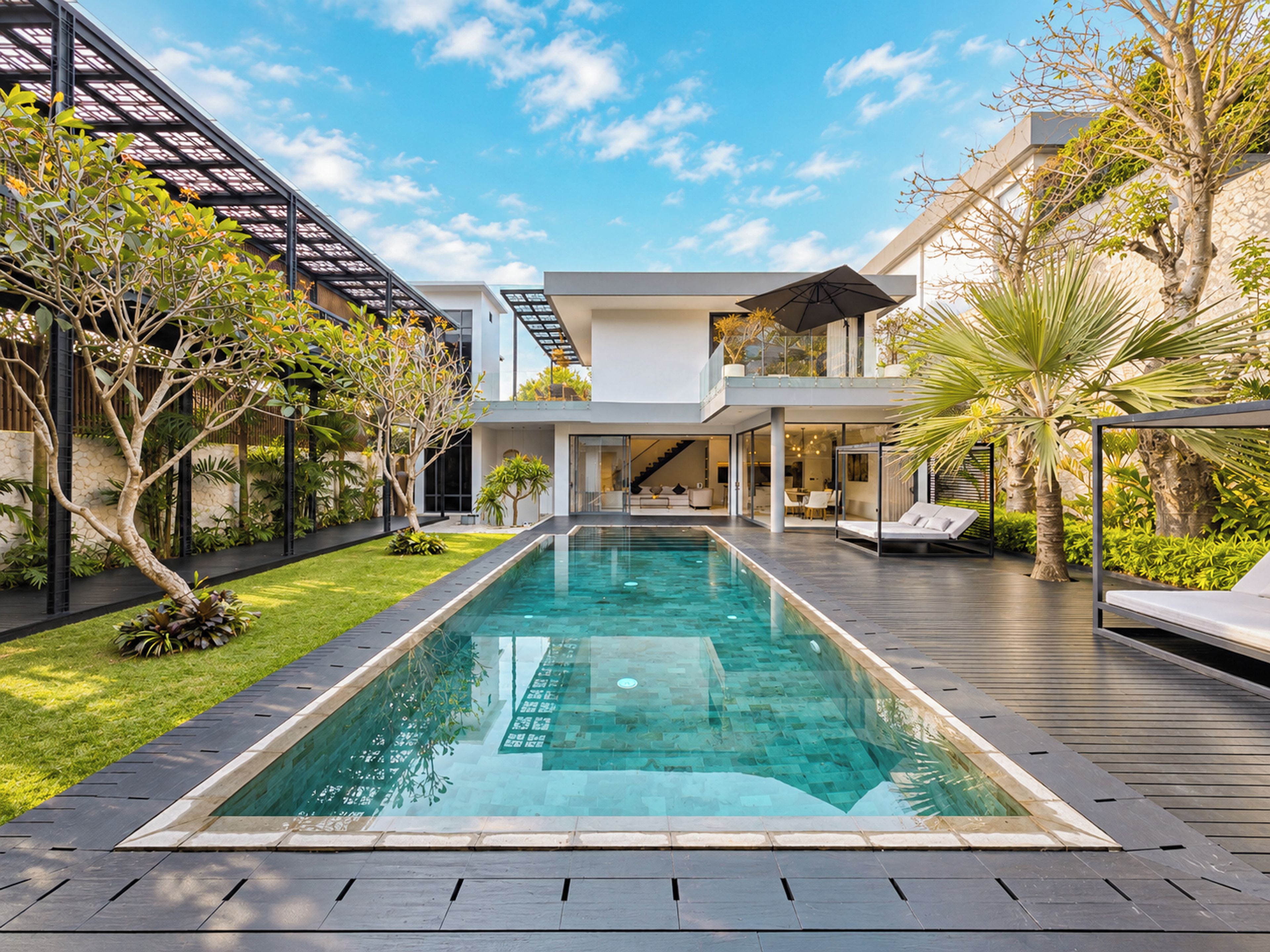 Una casa moderna con piscina, un porche cubierto y una escalera que conduce a un segundo piso.