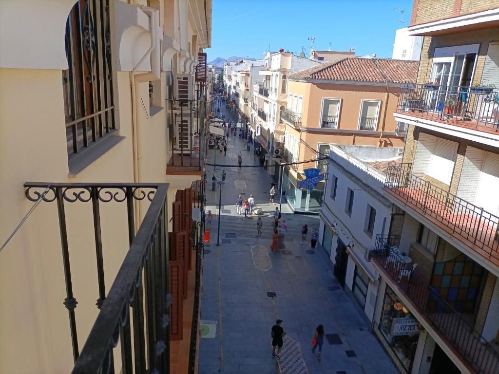 Une vue de rue avec des immeubles, un escalier et des piétons.