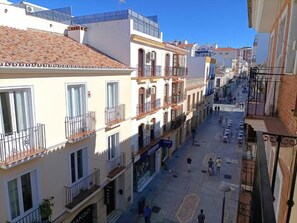 A street view with buildings, balconies, and a clear sky. - SIERRA RONDA CENTER—HYDROMASSAGE (Ronda)