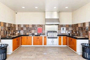 A modern kitchen with a gas stove, wooden cabinets, and patterned backsplash tiles. - Wariruri 214 by Bocobay • Luxury Resort Stay (Noord)