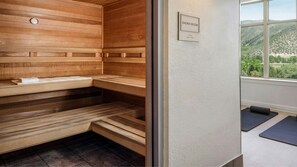 Ein Saunaraum mit Holzbänken und einer Uhr an der Wand.