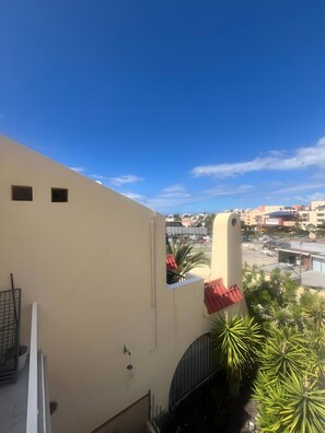 A building with a flat roof, a small balcony, and a view of a cityscape with various buildings and a clear sky. - Vacation Apartment 'Precioso Mareverde' with Shared Pool, Wi-Fi and Air Conditioning (Costa Adeje)