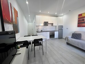 A modern kitchen with white cabinets, a microwave, and a refrigerator. - Vacation Apartment 'Precioso Mareverde' with Shared Pool, Wi-Fi and Air Conditioning (Costa Adeje)