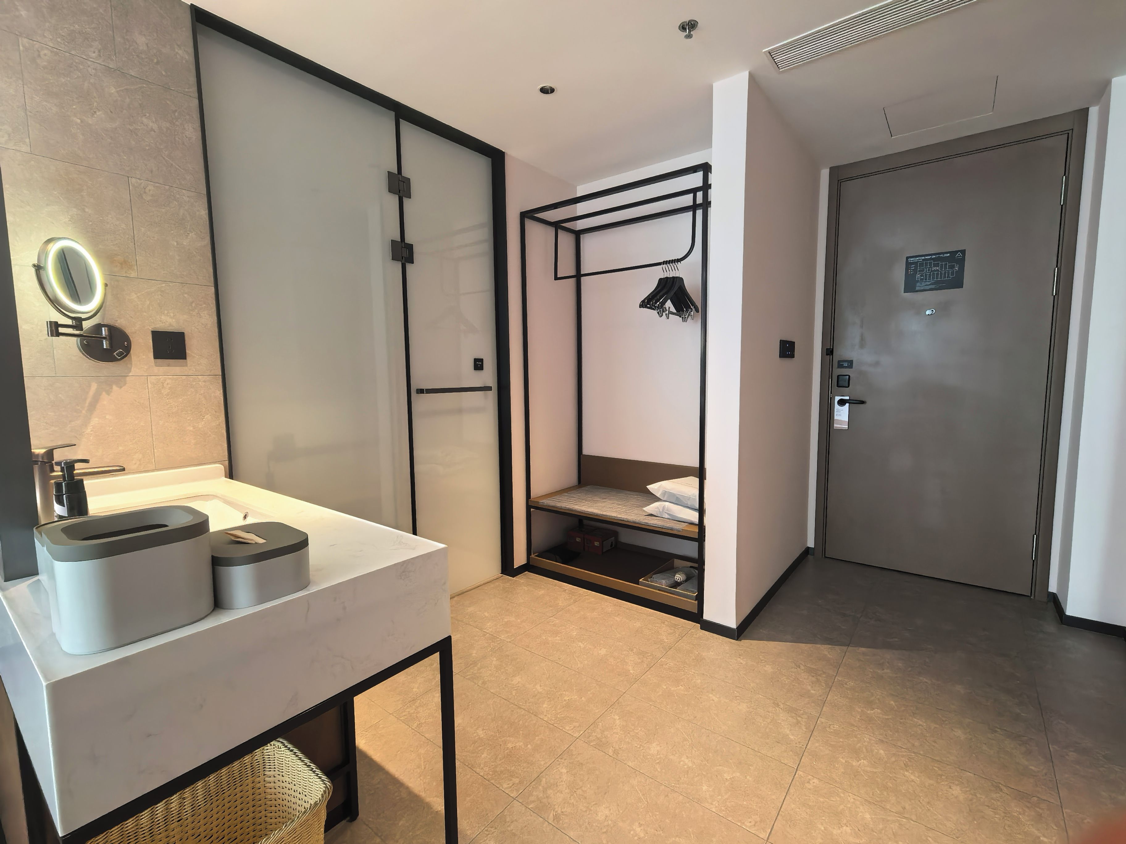 Une salle de bain moderne avec un grand miroir, un lavabo et un espace douche.