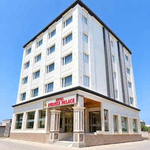 A multi-story hotel with a prominent entrance and a sign reading 'HOTEL D'WARKA PALACE'. - Hotel Dwarka Palace (Dwarka)