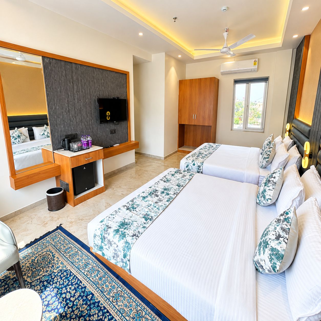 Habitación de hotel con una cama grande, televisión, armario, escritorio con computadora y ventana.