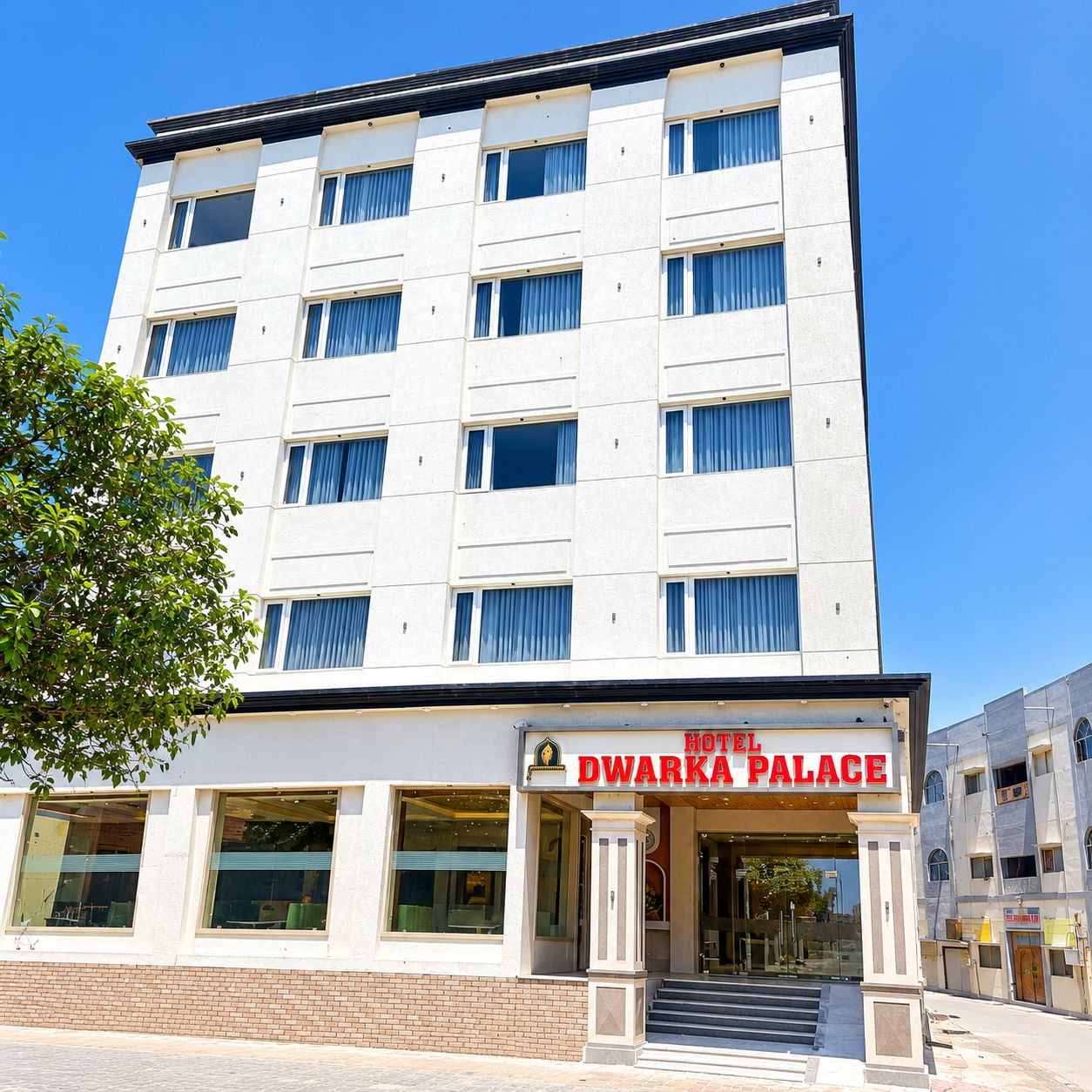 Un hotel a più piani con un cartello che indica 'Hotel Dwarka Palace'.