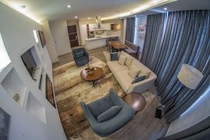 A modern living room with a sofa, armchairs, a coffee table, and a dining area. - Rapenda 2bedroom Park View Apartments (Nairobi)