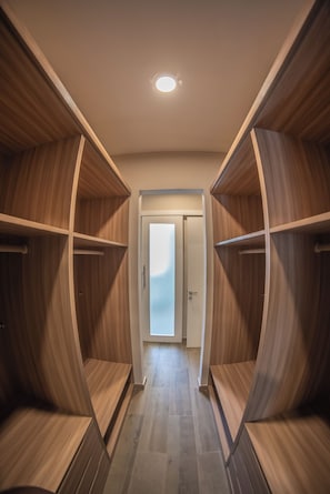 A modern closet with curved wooden shelves and a door leading to a room. - Rapenda 2bedroom Park View Apartments (Nairobi)