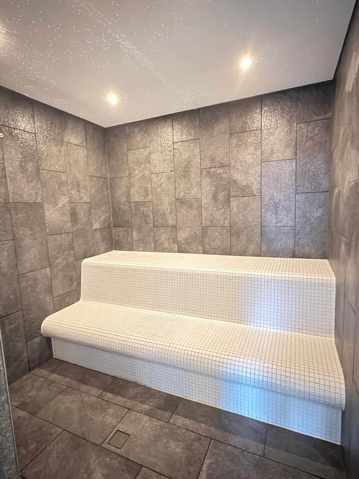 A modern bathroom with a large, rectangular bathtub, tiled walls, and a shower area.
