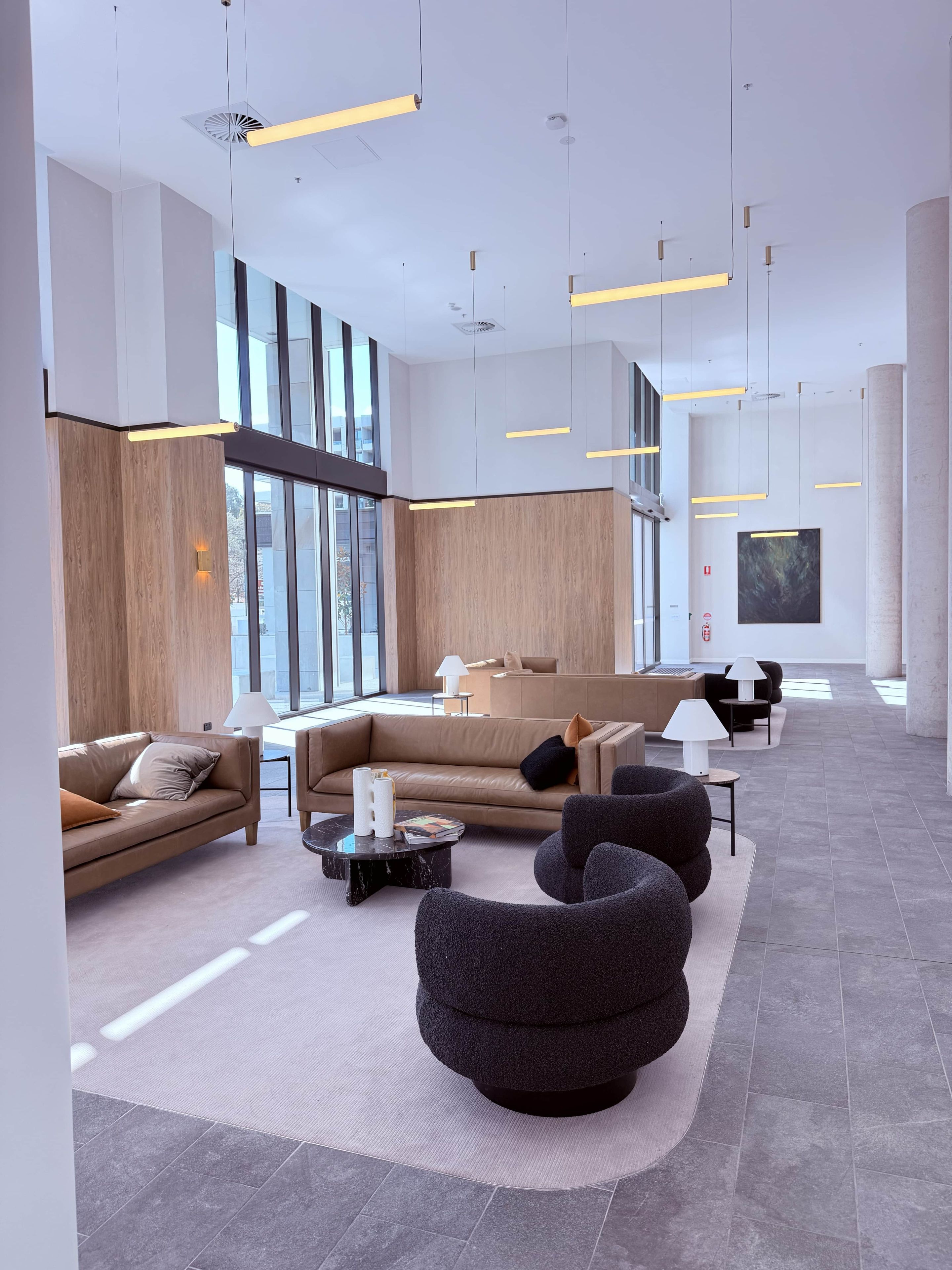 A modern interior with a sectional sofa, round ottoman, and a coffee table.