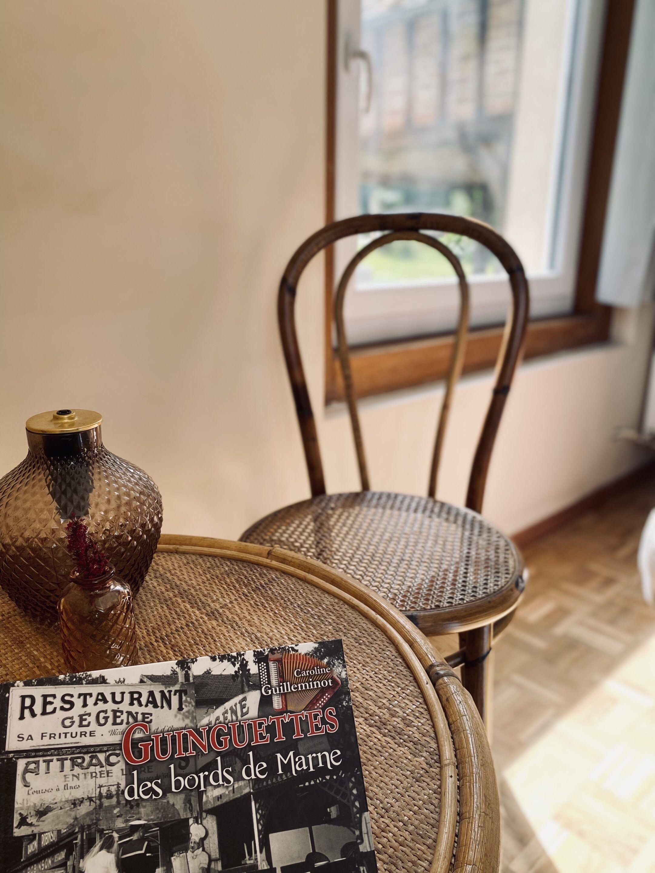 Een rieten stoel en een tafel met een decoratieve vaas en een menukaart.