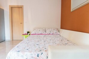 A bedroom with a bed, a bedside table, and a door. - Apartments Villa Monique: 1-Bedroom Apartment (Rogoznica)