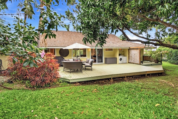 A house with a deck, a patio with furniture, and a washing machine. - Lush Tropical Home Close to the Ocean - Mana Hale (Kihei)