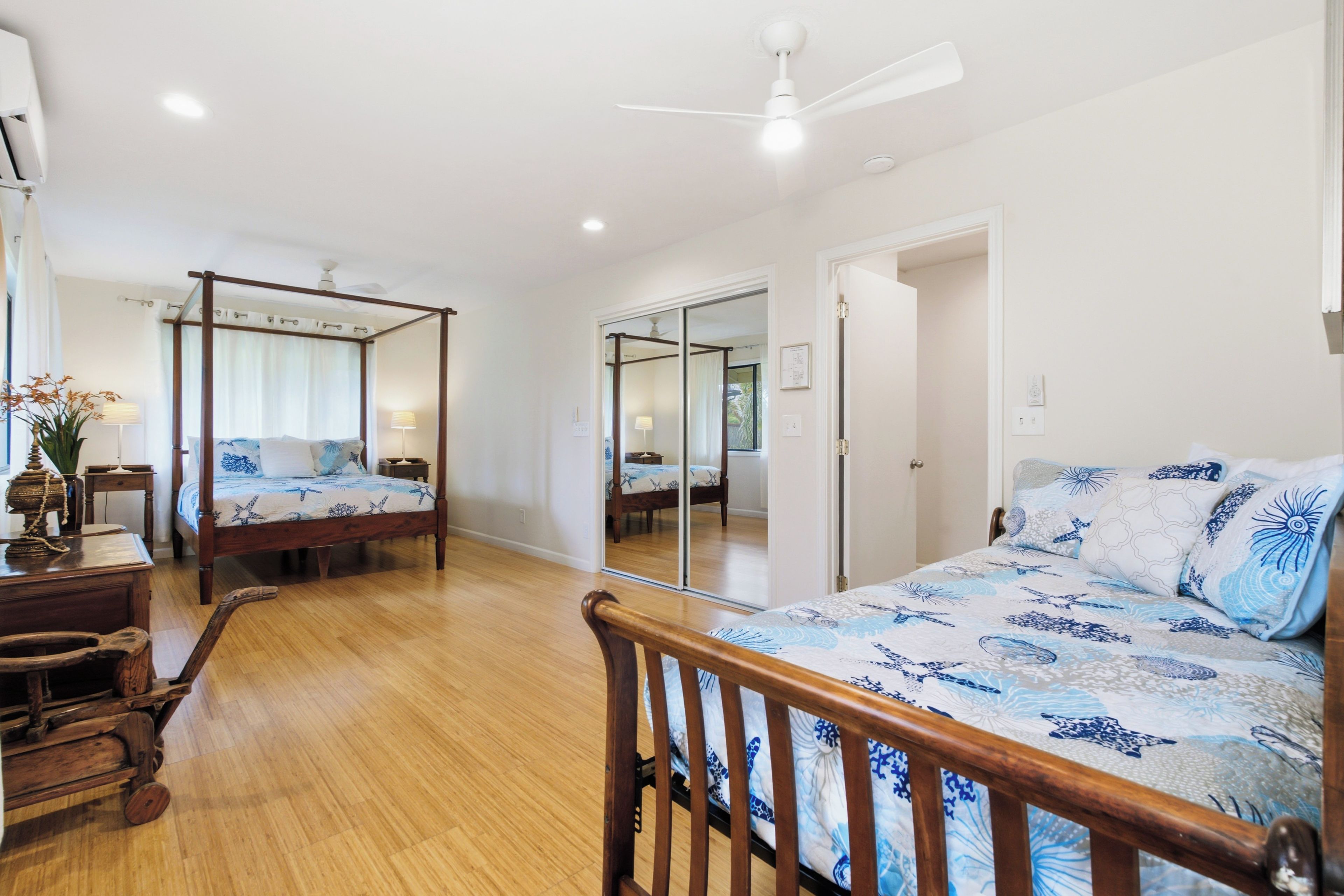 A bedroom with a four-poster bed, a wooden nightstand, and a bedside table.