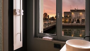 Une salle de bain avec une fenêtre, un lavabo et un porte-serviettes.