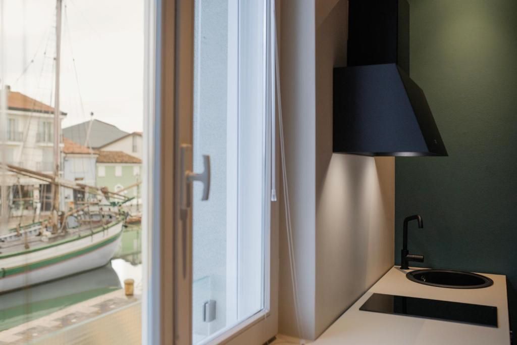 A kitchen with a window view of a docked boat and a modern sink.