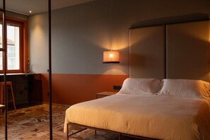 Une chambre à coucher avec un lit, une table de chevet, une lampe et une fenêtre.