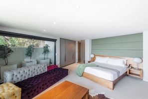 Une chambre moderne avec un grand lit, un canapé et une table à manger.