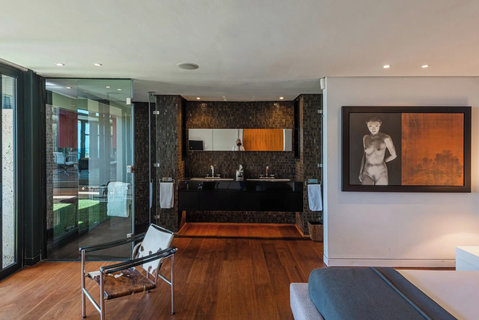 A modern kitchen with a black countertop, wooden cabinets, and a glass door leading to a dining area.
