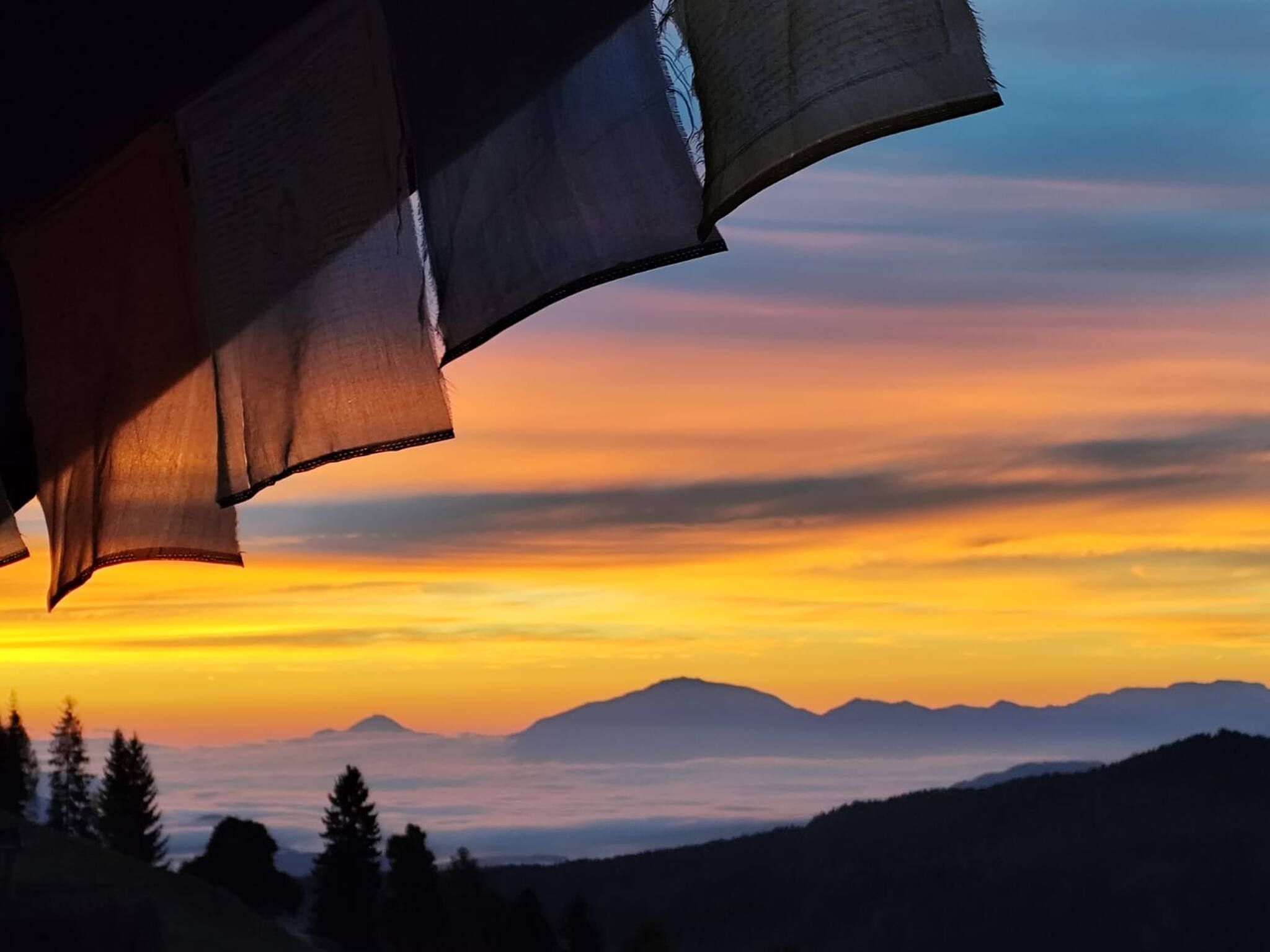 Un paysage montagneux au coucher du soleil, avec un ciel dégagé.