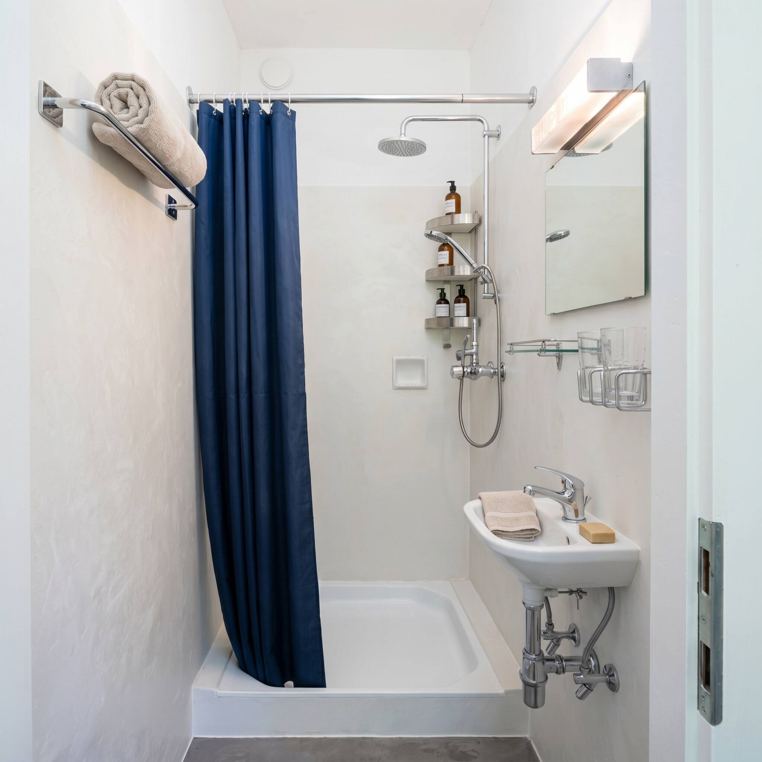 Un baño moderno con ducha, lavamanos y espejo.