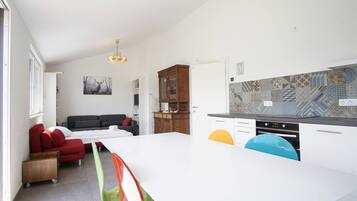 A modern kitchen with a white countertop, a built-in oven, and a backsplash with patterned tiles.