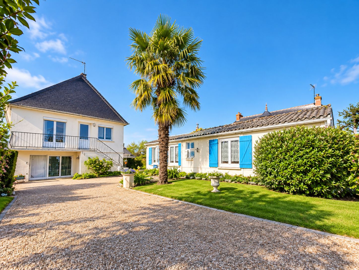 A two-story house with a gravel driveway and a well-maintained lawn.