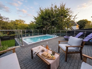 A rooftop terrace with a swimming pool, lounge chairs, and a table set with food and drinks. - House Sleeps 11 With Outdoor Pool (Lymington)