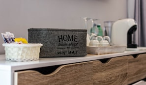 A home service basket with a label, a basket with cards, and a coffee maker on a counter. - Copy of President Gardens (Rome)