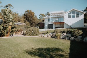 A modern two-story house with a large garage, a covered patio, and a well-maintained lawn. - BUSHMERE ~ Gateway to the Bay of Fires at Binalong Bay (Binalong Bay)