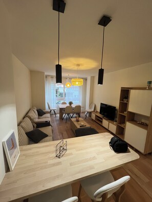 A modern living room with a sofa, a dining table, and a TV. - Large House in Downtown Alicante (Alacant)
