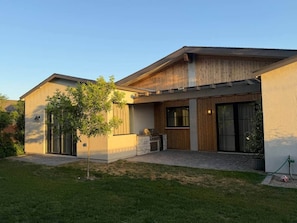A modern two-story house with a patio, a small tree, and a grill. - New Ultra Luxury Retreat minutes from Arcadia! (Phoenix)