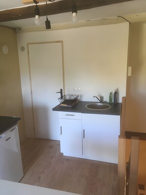A compact kitchen with a sink, countertop, and cabinets. - Cottage 'L'entredeux' with Shared Terrace, Shared Garden and Wi-Fi (Saint-Viaud)