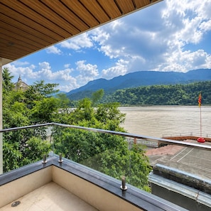 Un balcon avec vue sur une rivière et des montagnes.