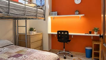Een studentenkamer met een stapelbed, bureau, stoel en een klok aan de muur.