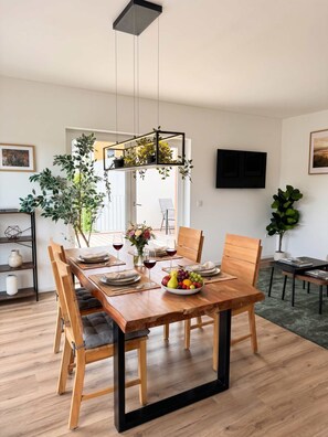 Een eetruimte met een houten tafel voor zes personen, omringd door stoelen.
