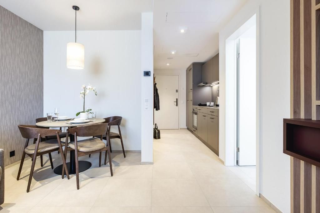 Una cocina moderna con horno empotrado y comedor con mesa redonda y sillas.