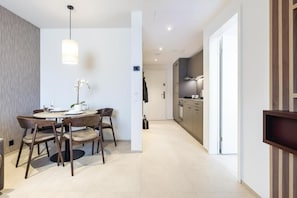 Una cocina moderna con horno empotrado y comedor con mesa redonda y sillas.