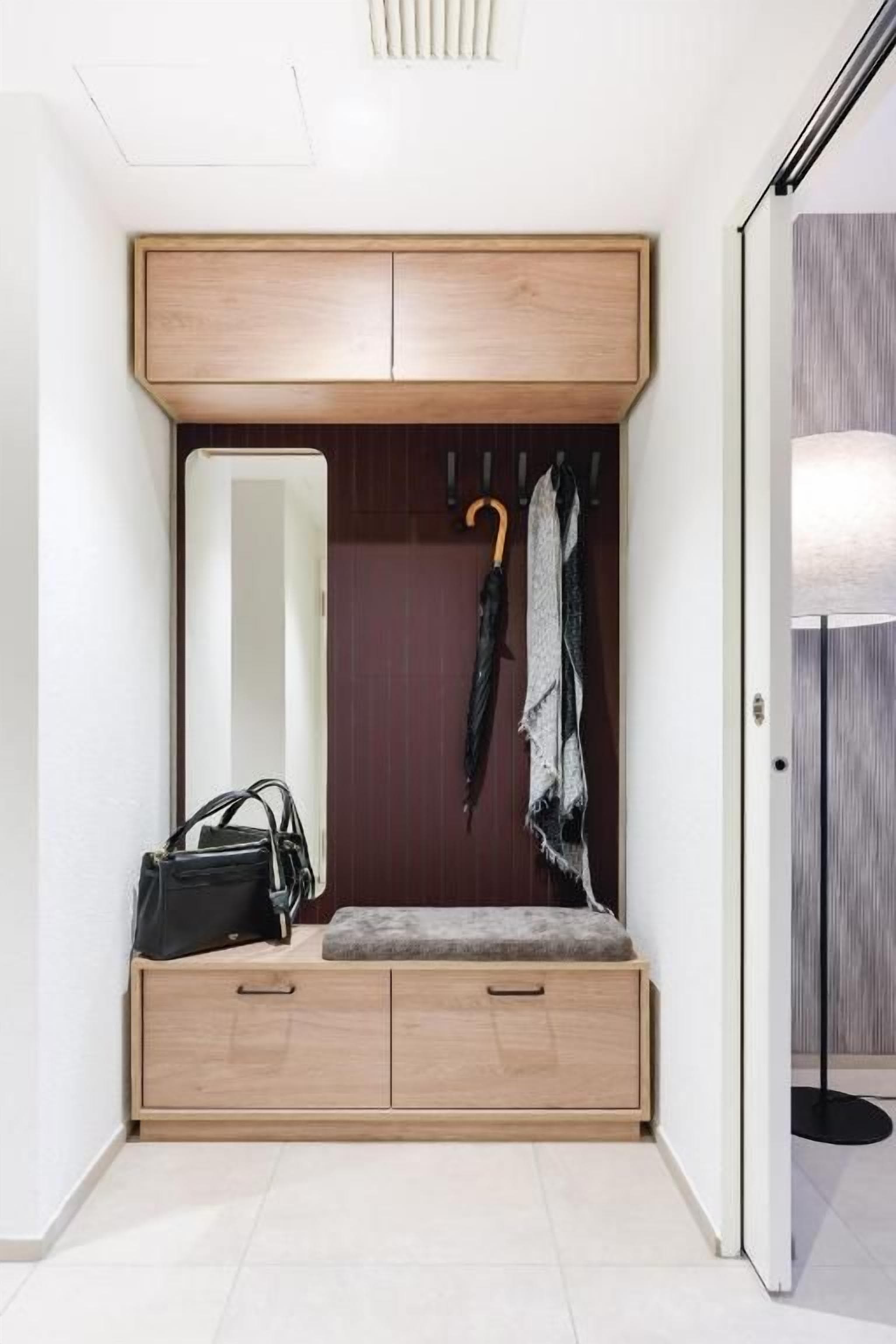 A walk-in closet with a bench, a mirror, and a coat rack.