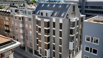 Un edificio de varios pisos con un diseño arquitectónico moderno, que combina balcones y grandes ventanales.