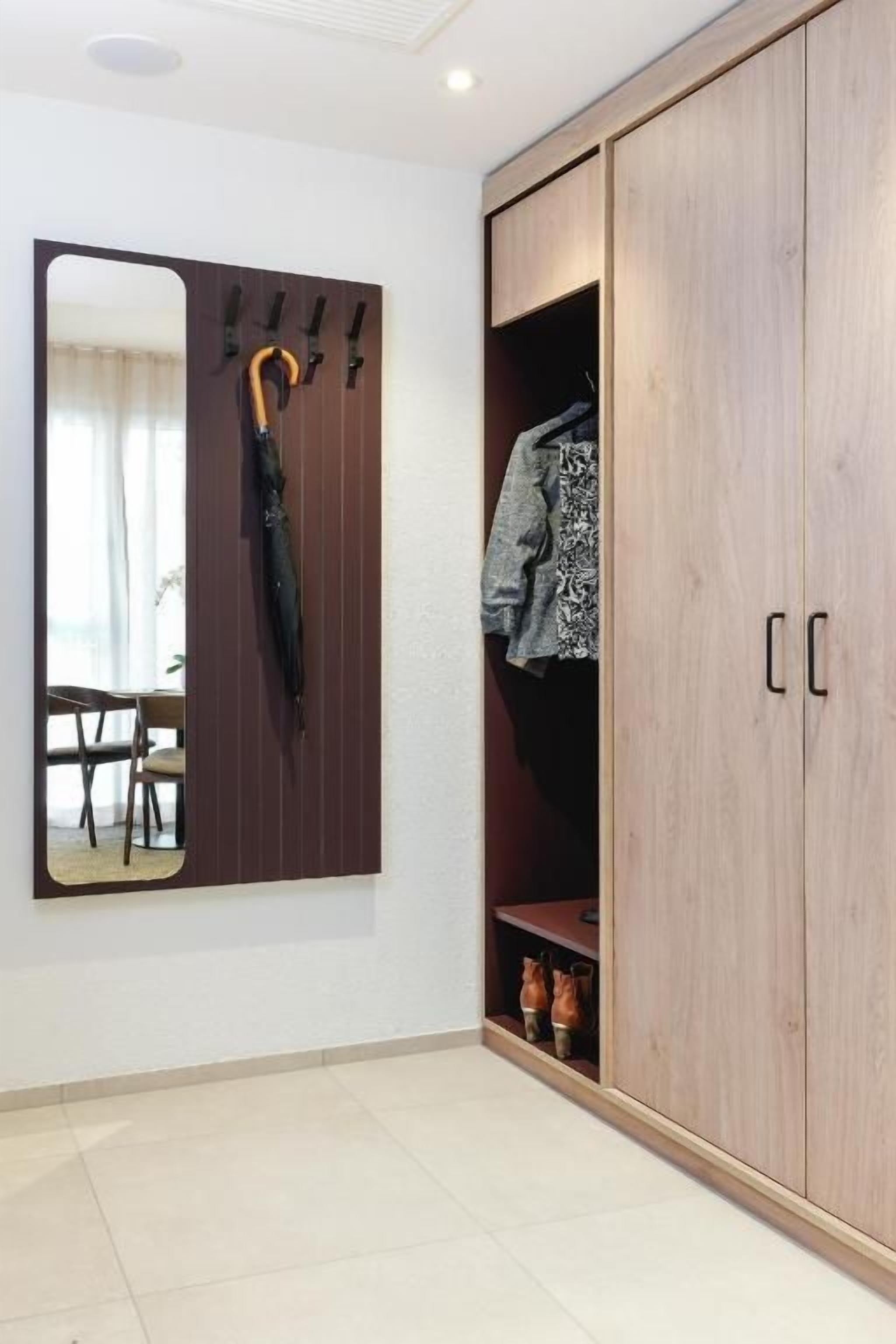 A room with a wardrobe, a mirror, and a coat rack.