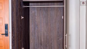 Un armario con acabado en madera oscura, puerta corredera y un cajón pequeño.