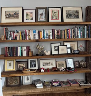 Een boekenplank met verschillende boeken en ingelijste foto's.