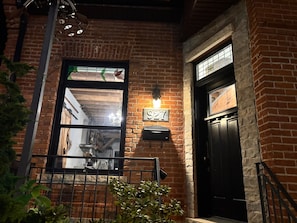 A brick building with a black door and a window with a number plaque. - Private Downtown Toronto Apartment in the Annex with Free Parking (Toronto)