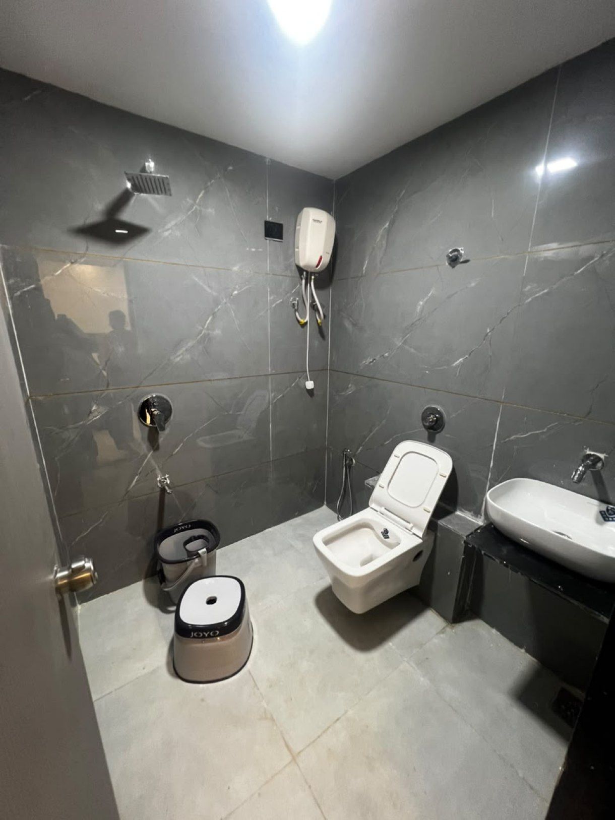 A compact bathroom with a toilet, bidet, and sink.