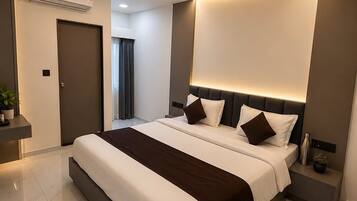 Quarto moderno com cama grande, ventoinha no teto e iluminação embutida.